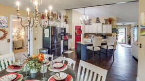 A spacious kitchen with white cabinets, a central island, and a dining area with a table set for four.