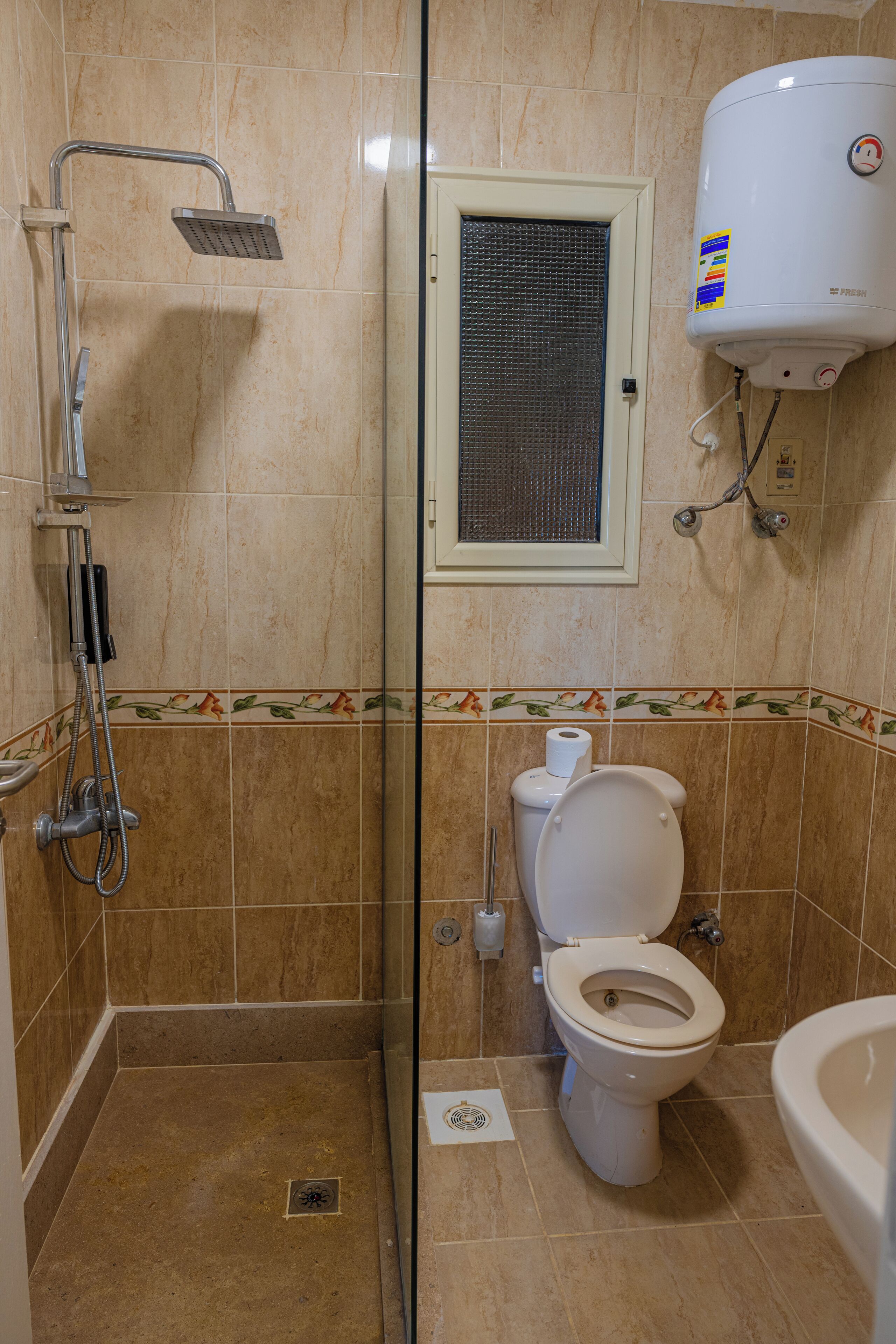 Un baño con ducha, inodoro y lavabo.