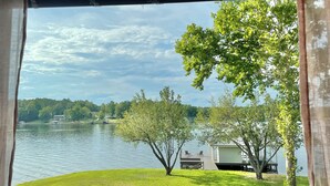 A lakeside view with a grassy area, a dock, and a small building. - Luxurious large 3bd/2ba Home with Dock with beautiful sunset views (Eatonton)
