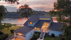 A two-story house with a garage, a covered porch, and a staircase leading to the second floor. - Luxurious large 3bd/2ba Home with Dock with beautiful sunset views (Eatonton)