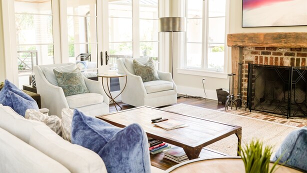 A spacious living room with a fireplace, large windows, and a cozy seating area.