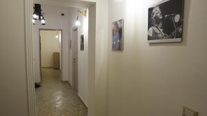A hallway with a light fixture, a framed picture, and a light switch. - Napul'è (Naples)