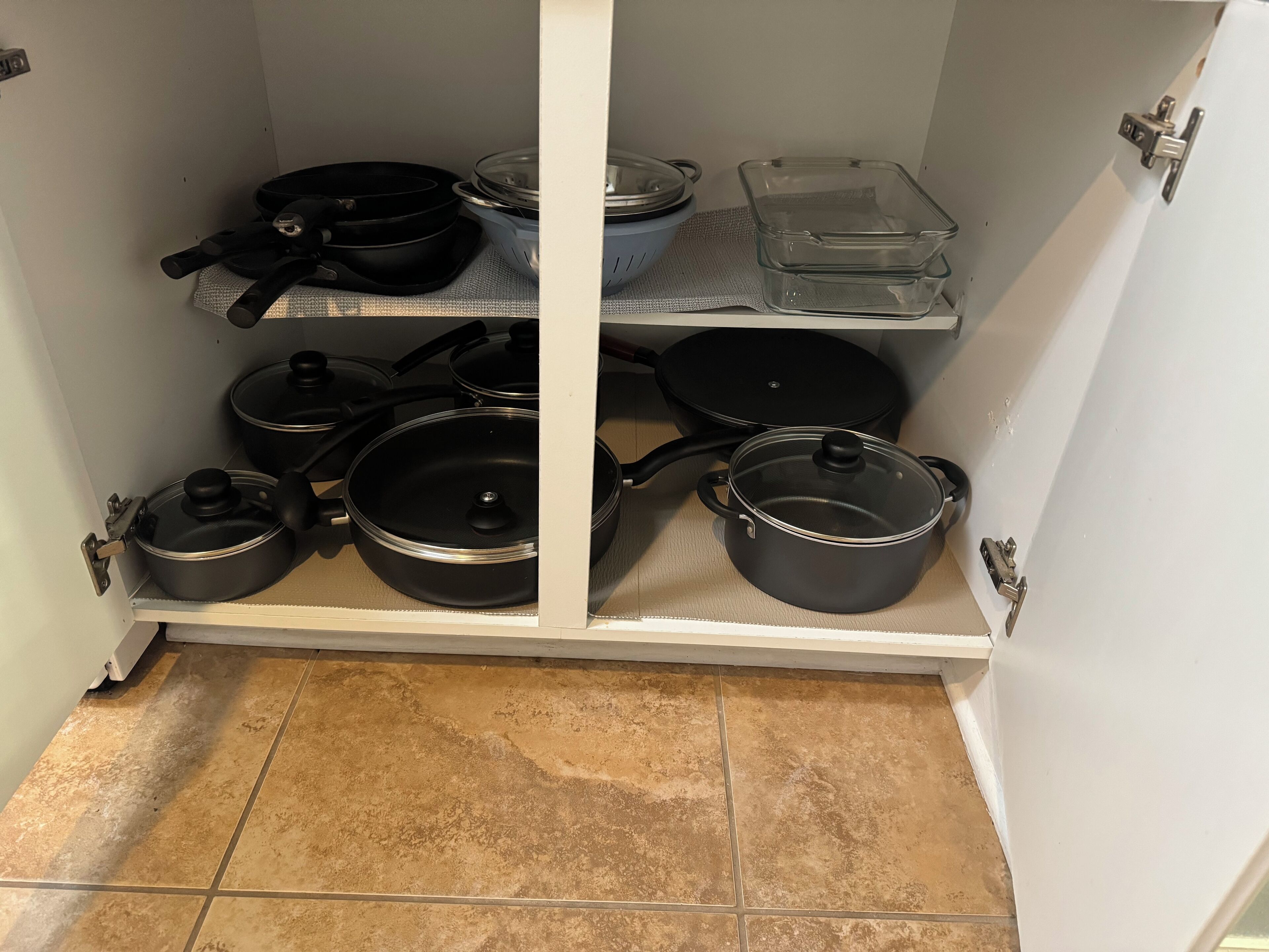 A kitchen pantry with shelves holding various pots and pans.