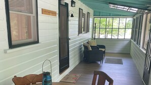 Ein Zimmer mit einem runden Holztisch, zwei Stühlen, einer Laterne und einem Sofa.
