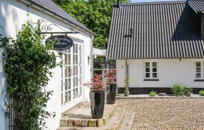 A building with a signboard advertising a farm-to-table breakfast, a cobblestone courtyard, and a traditional tiled roof. - 4 bedroom nice home in Ejstrupholm (Ejstrupholm)