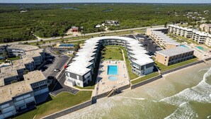 A coastal hotel with a pool, beach access, and a view of the ocean.