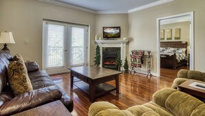 Una sala de estar con chimenea, un sofá, una mesa de centro y un televisor.