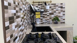 A kitchen with a tiled backsplash, a stove, and a sink.