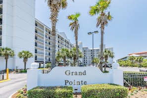 Señal para el hotel Grand Pointe, con un edificio moderno al fondo.