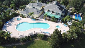Una casa grande con piscina, varias terrazas y cancha de tenis.