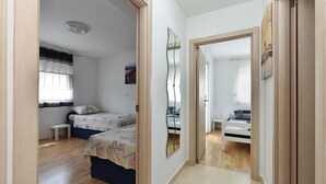 A narrow hallway with a bed on the left and a door leading to another room on the right. - Apartment 2333/111878 (Istria - Pula), 3000m from the beach (Pula)