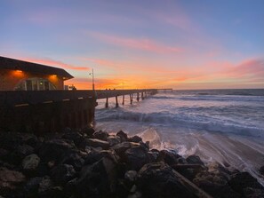 A pier extending into the ocean with a building on the left. - Beautifully Renovated 2B1B • Private Backyard • Steps to Beach • Free Parking (Pacifica)