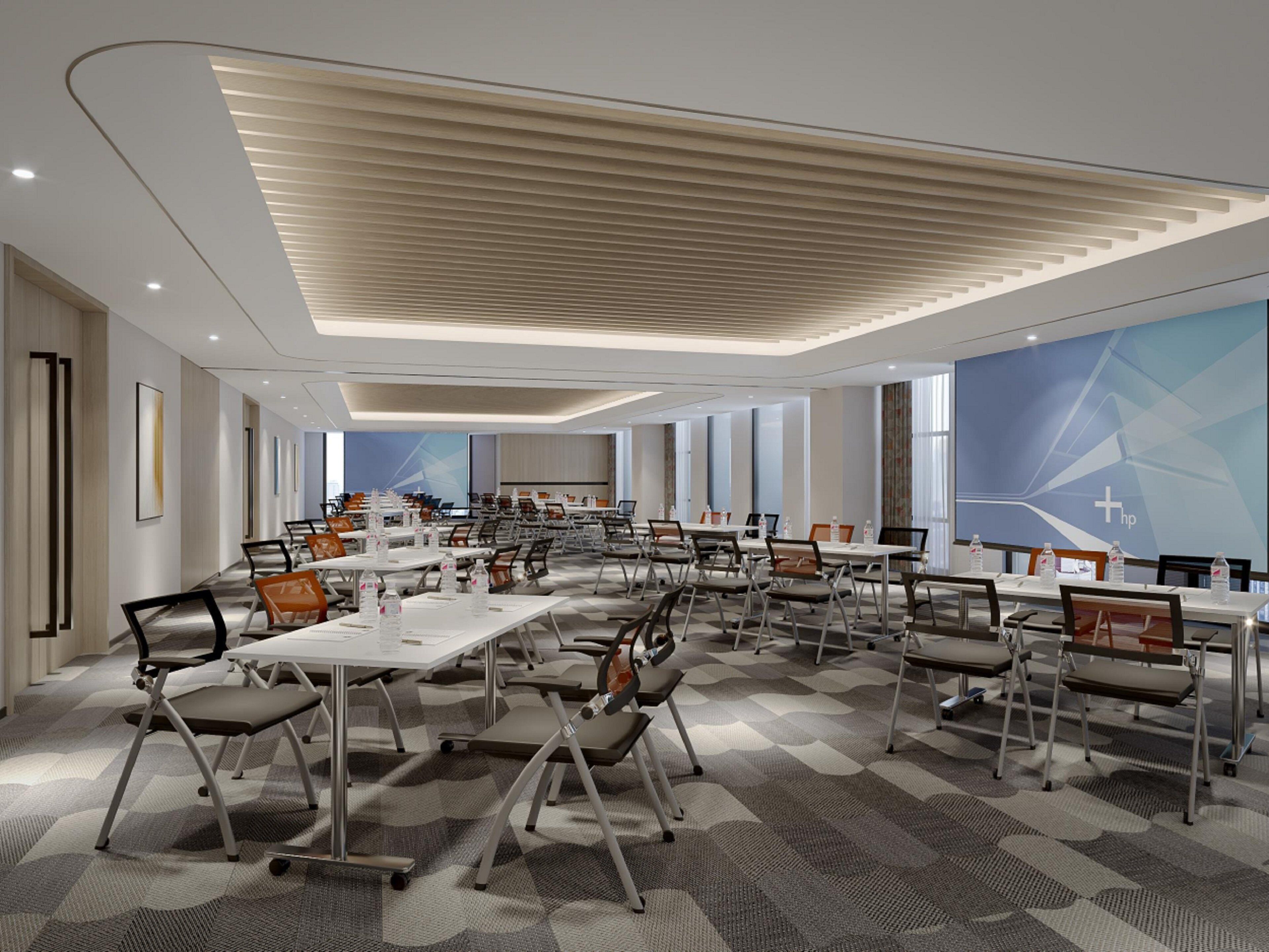 A modern conference room with multiple tables and chairs, large windows, and a geometric wall design.