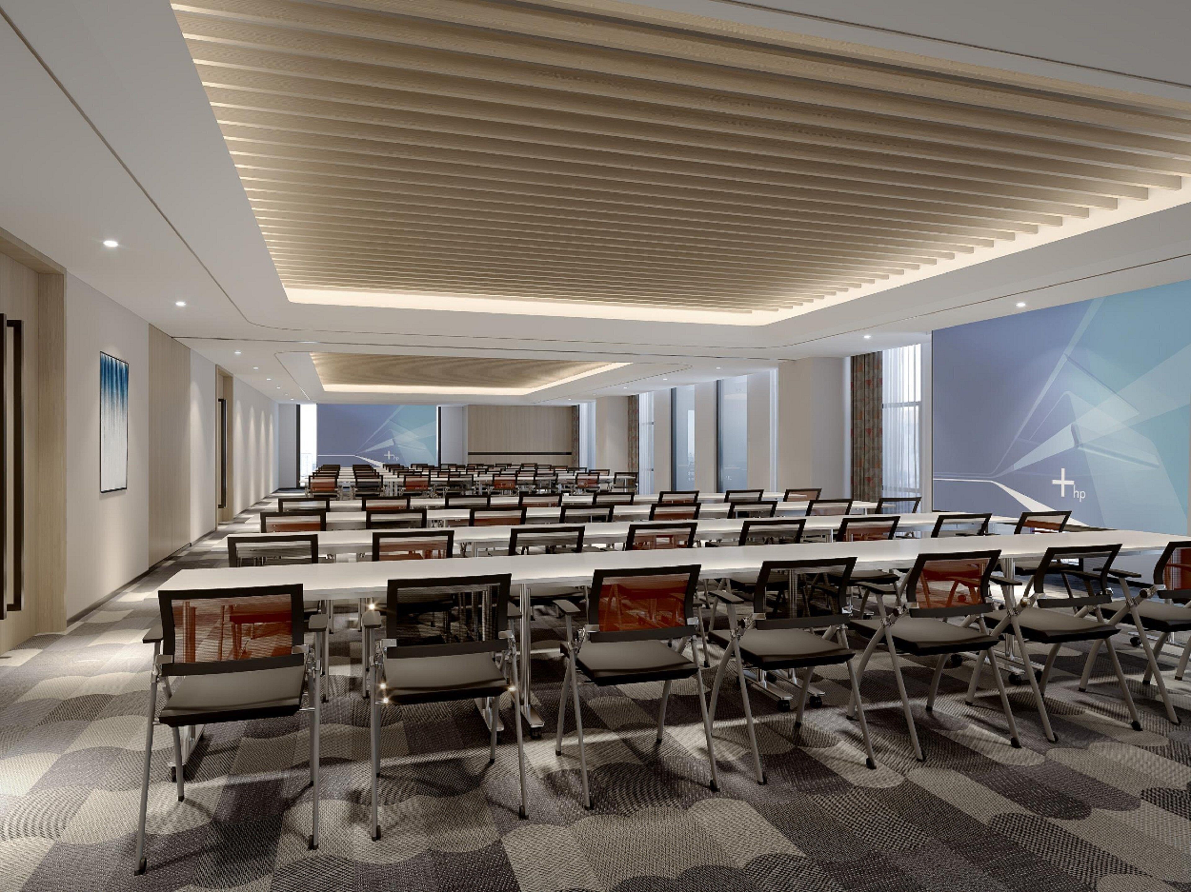 A conference room with a long table and chairs, large windows, and a modern ceiling design.