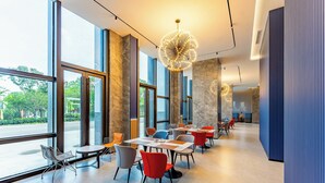 Un ristorante moderno con ampie vetrate, diversi tavoli e sedie.