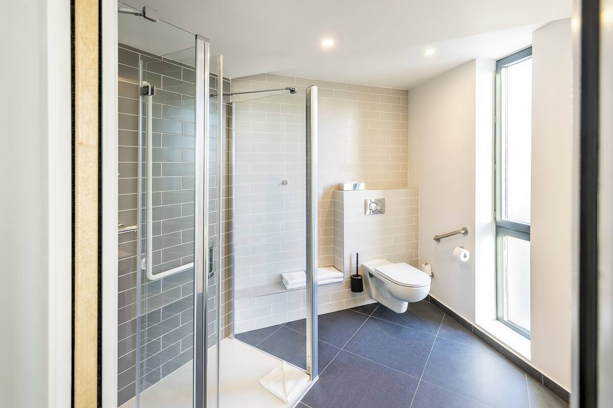 Et moderne badeværelse med brusekabine, toilet og vask.