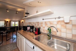A modern kitchen with a wooden countertop, stainless steel sink, and a coffee maker. - Villa Above by Istrabook (Medulin)