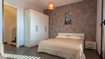 Ein Schlafzimmer mit Bett, Nachttischen, einem Kleiderschrank und einem Bild an der Wand.