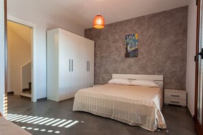 A bedroom with a bed, nightstands, a wardrobe, and a painting on the wall.