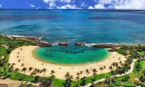 A tropical beach resort with a curved sandy beach, palm trees, and clear blue waters. - End of year specials! - BT701 Beautiful 3 Bed, 3 Bath (Kapolei)