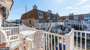 A coastal residential area with multiple two-story houses featuring balconies and a shared deck area. - Fenwick Island, 1 block to beach, 2 BR condo, Sleeps 6, 2 parking spots (Fenwick Island)