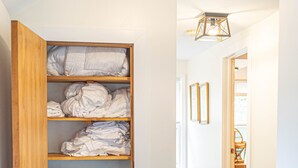 Un dressing avec des étagères en bois, un banc et un espace pour suspendre les vêtements.