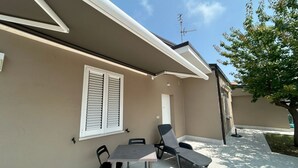 Una casa con un patio, una mesa y dos sillas.