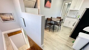 A modern kitchen with white cabinets, a wooden dining table, and a black refrigerator. - Casa Memphis Chic Basement Gem (El Paso)