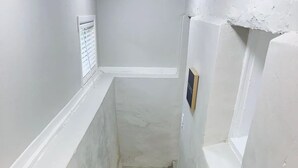 A narrow staircase with white walls and a wooden floor. - Casa Memphis Chic Basement Gem (El Paso)