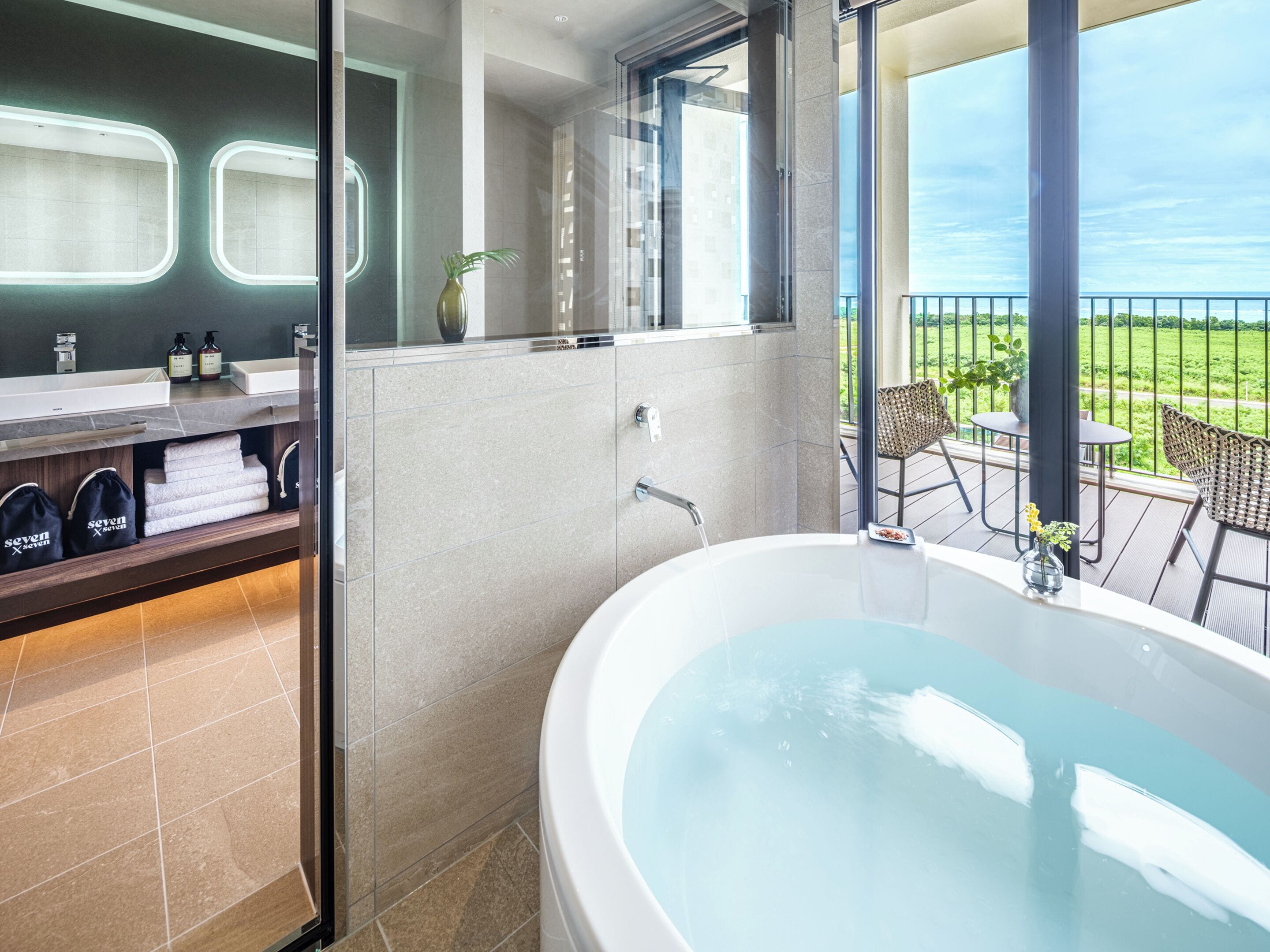 A modern bathroom with a large bathtub, a glass-enclosed shower, and a dual sink vanity.