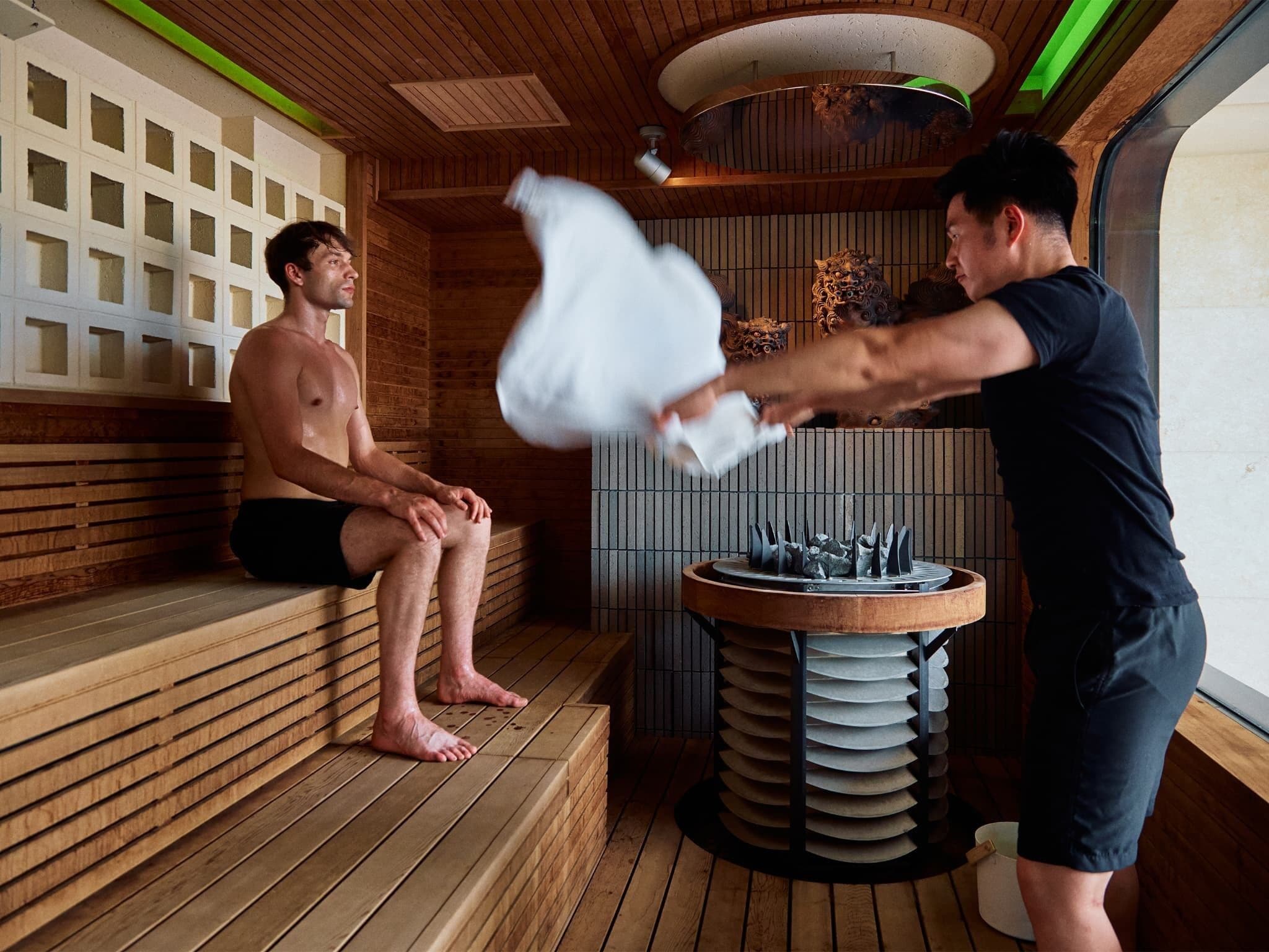 A sauna with wooden benches and a central heating table.