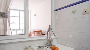 A bathroom with a white sink, a mirror, and a window.