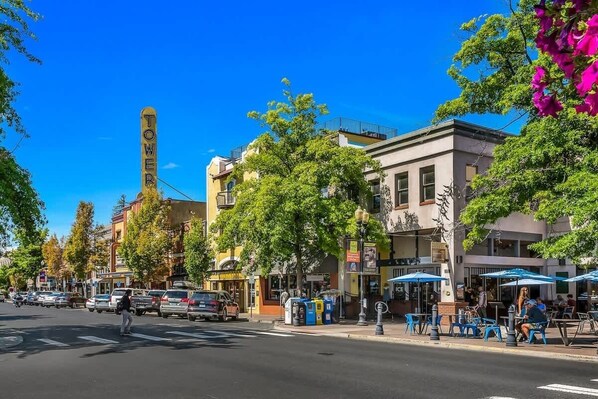 A street with buildings, a crosswalk, and cars.