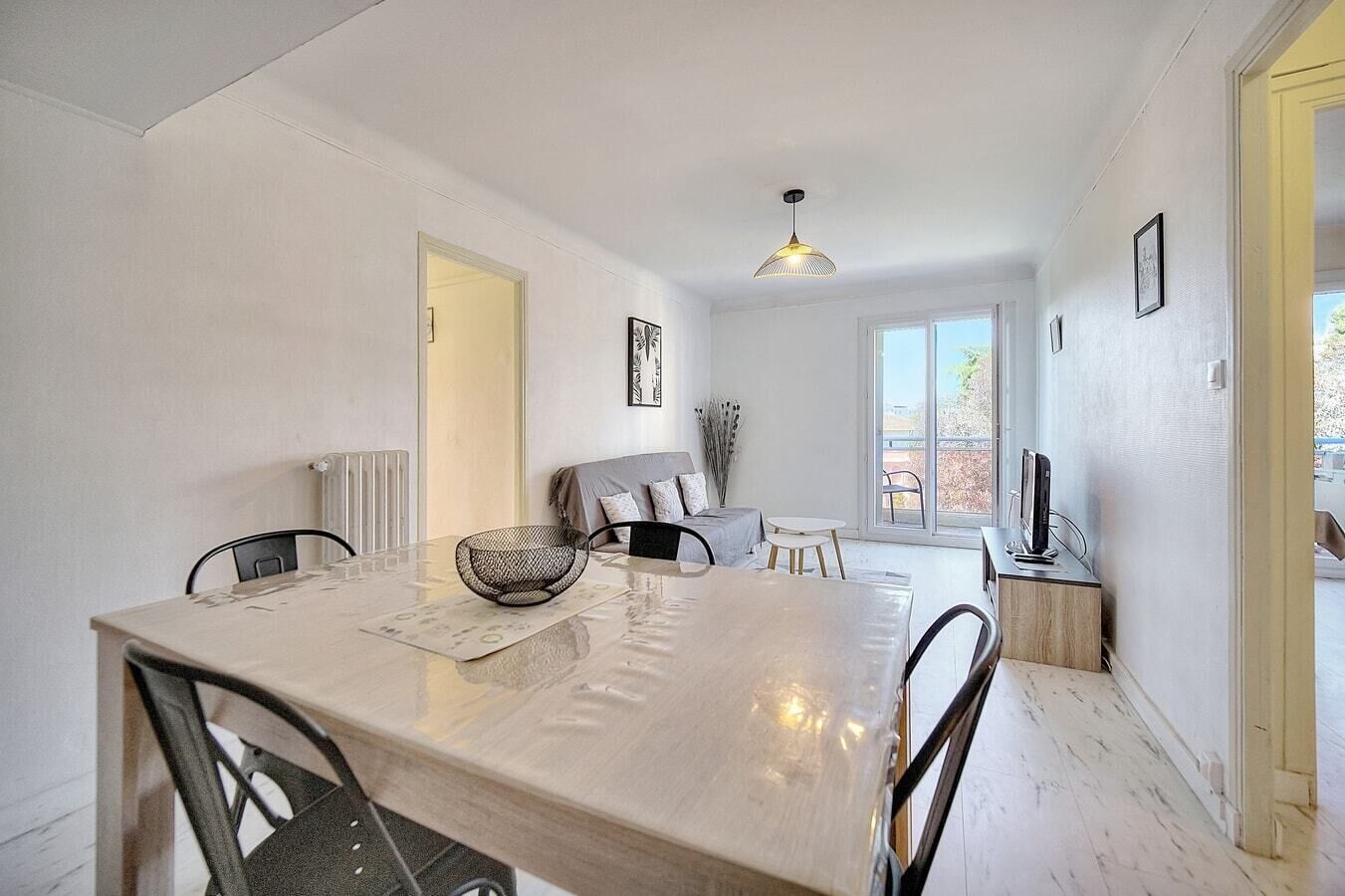 Un'area pranzo moderna con un tavolo grande, sedie e un lampadario.