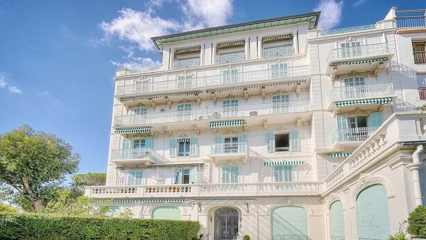 A multi-story building with balconies, a covered entrance, and a well-maintained garden. - Upstays Garden Terrace 74m² Apartment (Cannes)
