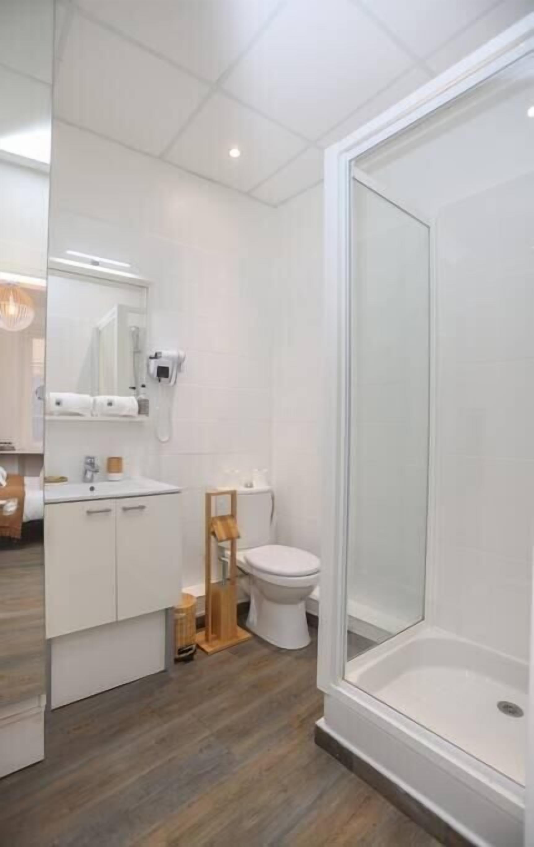 Een moderne badkamer met douche, toilet en wastafel.