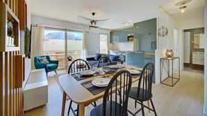Un appartement moderne comprenant un coin repas, une cuisine et un balcon.