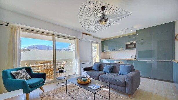Un salon moderne avec un canapé, une table basse et une vue sur l’extérieur.
