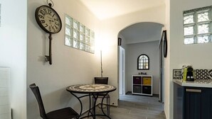 Een moderne keuken met een ronde tafel, stoelen, een klok en uitzicht op de eetruimte.