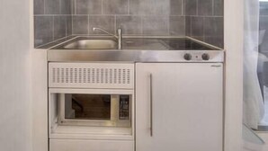 Una kitchenette compacta con estufa, pileta y alacenas.