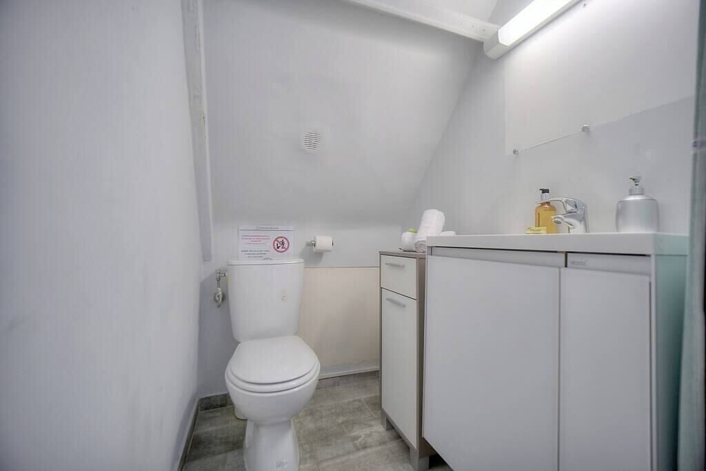 A small, white bathroom with a toilet, a sink, and a cabinet.
