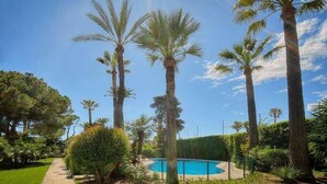 A pool surrounded by tall palm trees and lush greenery. - Upstays Sea View Pool Terrace 75m² Apartment (Cannes)