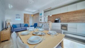 A modern kitchen with white cabinets, a wooden countertop, and a coffee machine. - Upstays Sea View Pool Terrace 75m² Apartment (Cannes)
