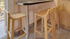 A modern kitchen with a central island, two wooden bar stools, and pendant lighting. - Upstays Terrace 24m² Studio Carnot (Cannes)