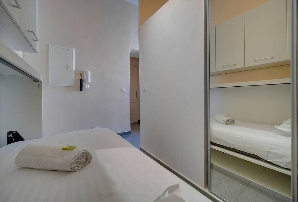 Ett hotellrum med en säng, ett badrum och ett litet kök.