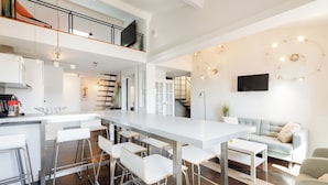 A modern kitchen with a central island, bar stools, and a dining table. - Upstays Port View 88m² Apartment Suquet (Cannes)