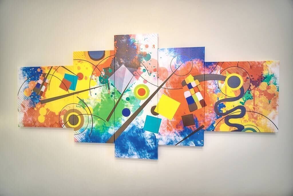 Una pintura abstracta con varios paneles, formas geométricas y salpicaduras de color.