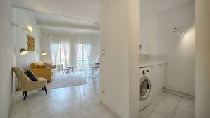 Un apartamento moderno con sala de estar, comedor y lavadero.