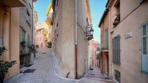 A narrow street with buildings on both sides, a visible staircase, and a sign that reads "Rue Panisse". - Upstays cosy 20m² Apartment Suquet (Cannes)