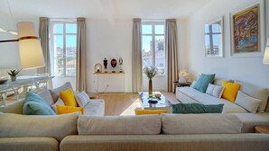 A modern living room with a sofa set, a coffee table, and a dining area with a table and chairs.